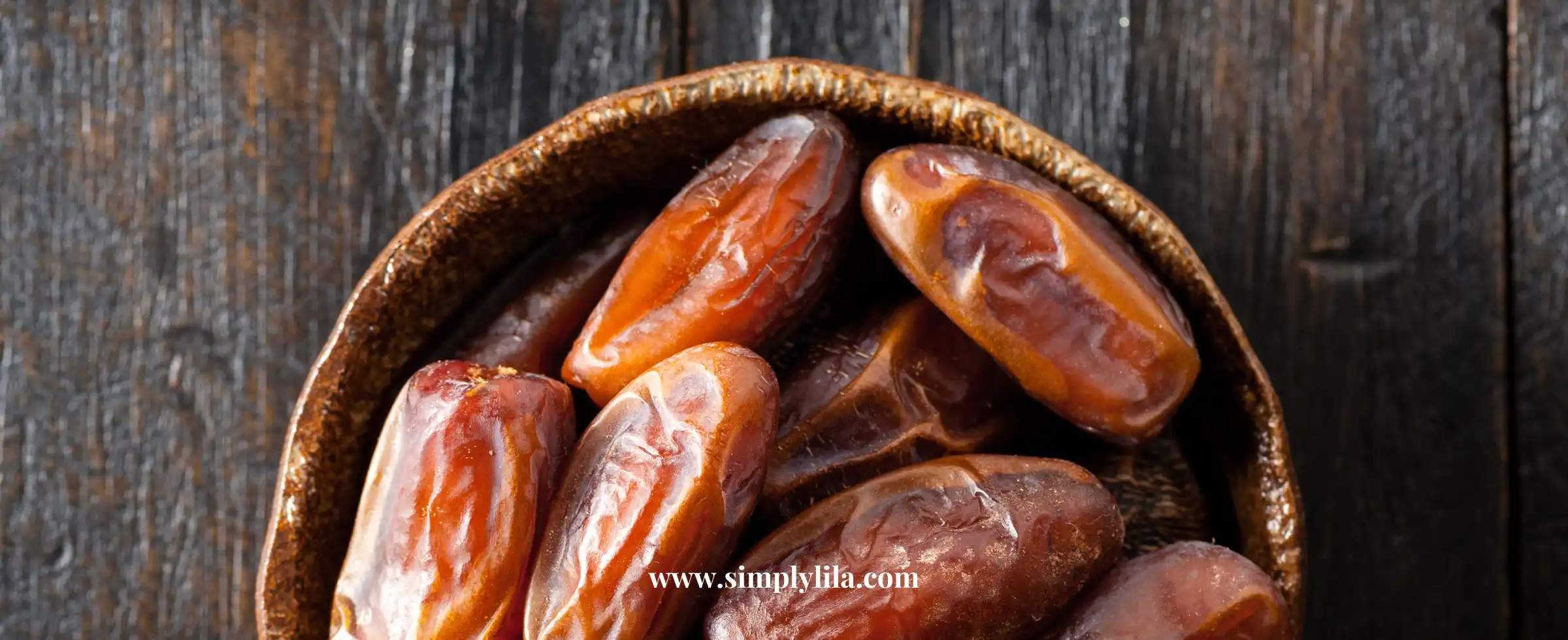 Bowl of medjool dates on dark wooden background
