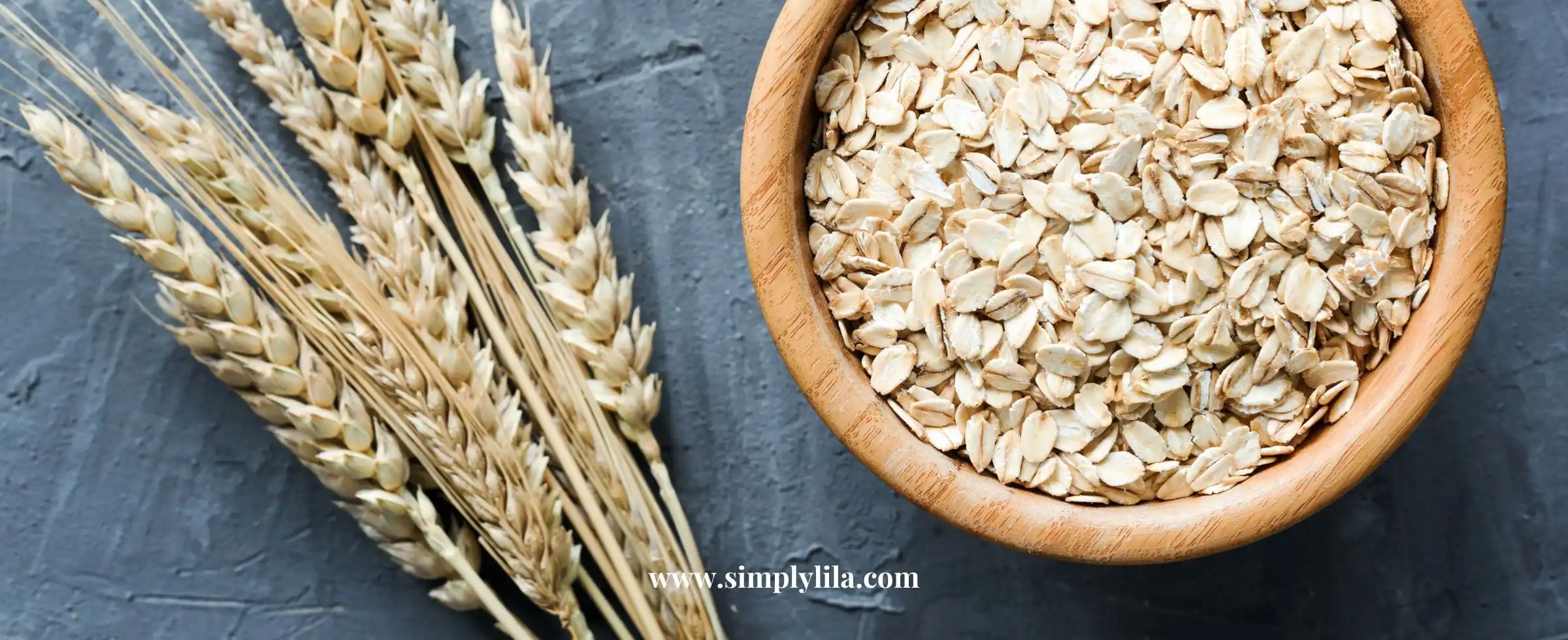 Rolled oats in wooden bowl with oat stalks for oatmeal bath