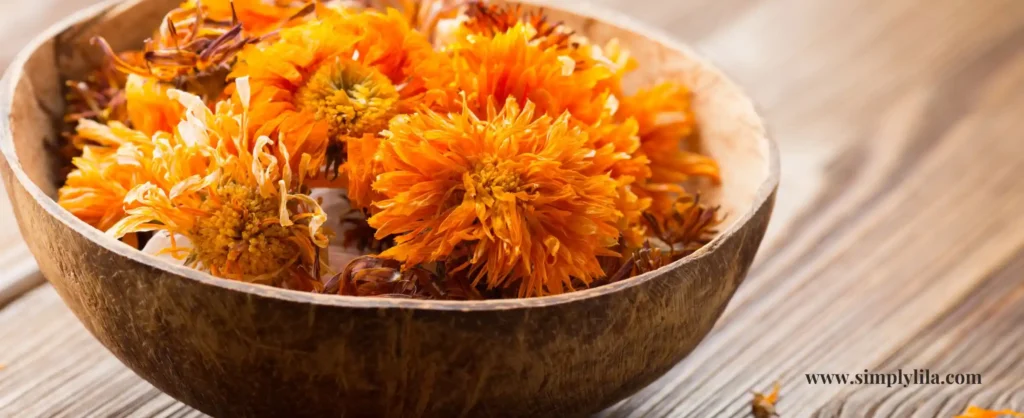 Dried calendula flowers in wooden bowl for herbal skincare