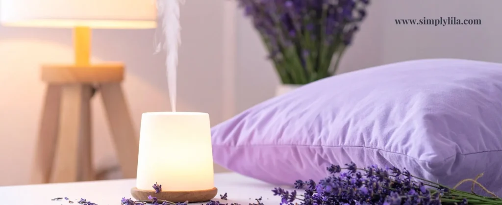 Glowing essential oil diffuser with steam beside fresh lavender sprigs and a purple pillow in a softly lit bedroom