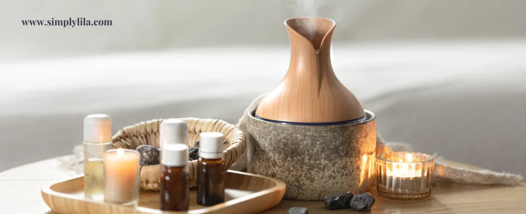 Wood grain ultrasonic essential oil diffuser with amber bottles, candles and lava stones on a warm natural surface