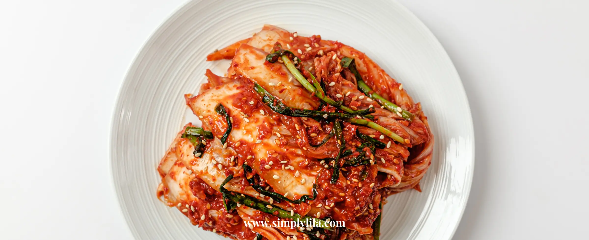 A white porcelain plate with fermented kimchi made of cabbage and different vegetables for gut health and flushing microplastics from the body